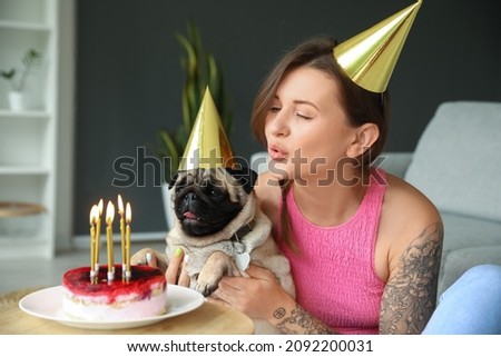 Young woman celebrating her dog's birthday at home