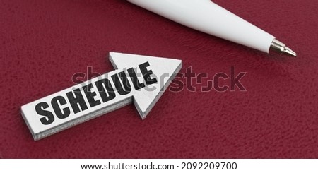Business and finance concept. On a red background lies a white pen and a white arrow with the inscription - SCHEDULE