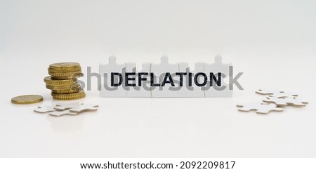 Business and finance. On a white background, there are coins and puzzles with the inscription - DEFLATION Royalty-Free Stock Photo #2092209817