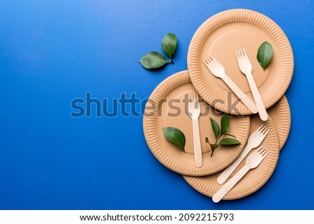 set of empty reusable disposable eco-friendly plates, cups, utensils on light white colored table background. top view. Biodegradable craft dishes. Recycling concept. Close-up.