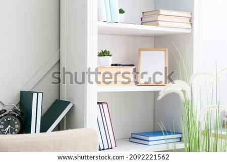 Shelf unit with books and picture frame in room