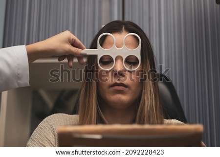 A girl undergoes an accommodation flexibility test with flippers at an optician. Royalty-Free Stock Photo #2092228423