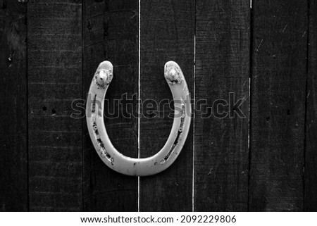 macro closeup of an old rusty aged weathered horseshoe horse shoe on wooden door symbol lucky charm of luck fortune and success 