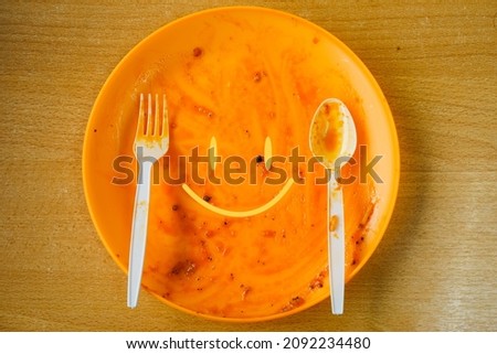 A picture of smile emoticon on empty plate after eat. 
