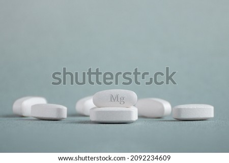 Tablets , vitamins with the abbreviation Mg ( magnesia, macro element magnesium ) on a light background. Copy space. Royalty-Free Stock Photo #2092234609