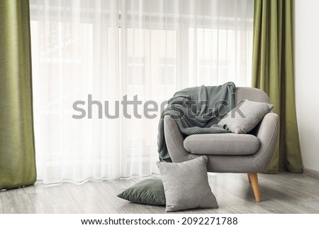 Comfortable armchair near light curtains in room Royalty-Free Stock Photo #2092271788