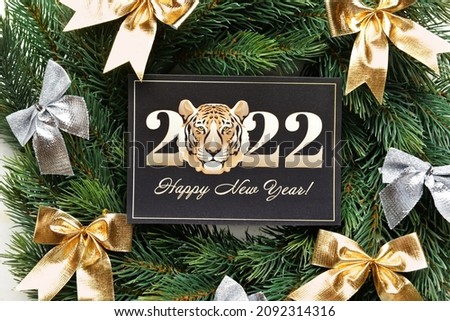 Greeting card for New Year 2022 celebration and coniferous wreath on white background, top view