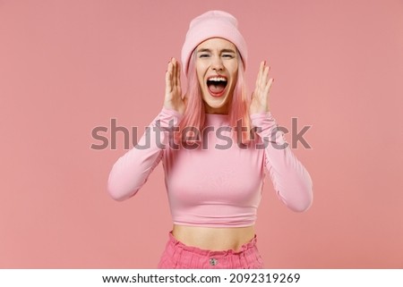 Young woman 20s with dyed rose hair in rosy top shirt hat scream hot news about sales discount with hands near mouth isolated on plain light pastel pink background. People lifestyle fashion concept