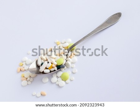 Pills, medicine, capsules with powder and a spoon on a light background, the concept of maintaining health, medication, vitamins, dietary supplements, drug addiction