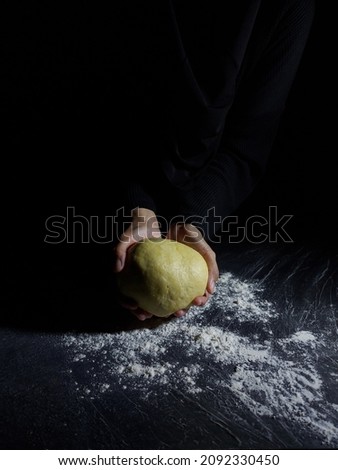 Women hand makes flour dough. Baking story photography. Dark mood. 
