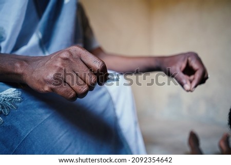 Close up hand holding silver razor blade to symbolize FGM in African poor communities household Royalty-Free Stock Photo #2092354642