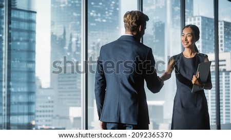 Female and Male Business Partners Meet in Office, Shake Hands. Corporate CEO and Finance Manager Have Meeting in City Office. Businesspeople Came to Discuss Real Estate Purchase and Marketing Project. Royalty-Free Stock Photo #2092365370