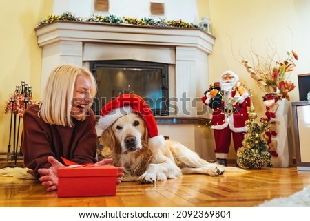 Photo of young woman and her pet enjoying together at home. Christmas time with my favorite person. Family celebrating christmas. Young woman celebrating New Year at home with her dog.


