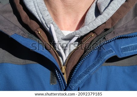 A man wearing many layers of clothing. Layering jackets in the winter. Types of fasteners: velcro, zipper, draw string. Royalty-Free Stock Photo #2092379185