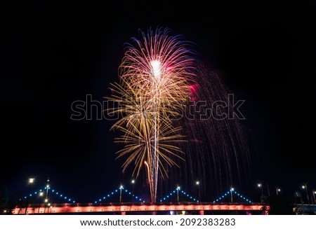 A beautiful colorful firework of the countdown to happy new year, the party time event. golden firework celebrates anniversary 2022, firework over the bridge at night.