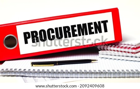 On the desktop are notebooks, a pen and a red folder for papers with the text PROCUREMENT Business concept