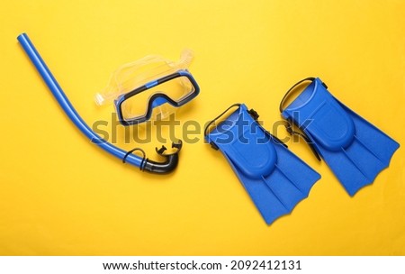 Snorkel, diving mask and fins on yellow background. Travel concept, vacation at sea. Flat lay, top view Royalty-Free Stock Photo #2092412131