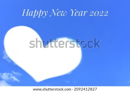 Happy New Year 2022 on blurred picture of sky wallpaper with Edited photo effect in shape of a heart from clouds and  sky background, use for new year card, advertising work, or wallpaper to artwork