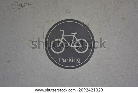 Old circle bicycle parking sign on the dirty wall.