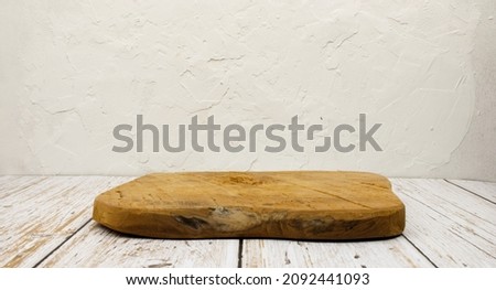 wooden board on a table in front of a white wall with a grunge effect