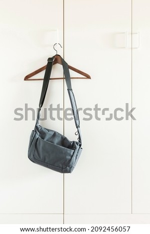 View of white wardrobe with hanging bag, interior