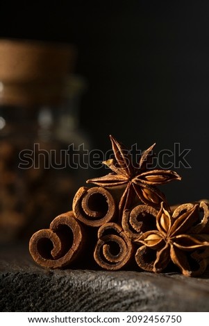 Traditional Christmas spices - Star anise with cinnamon sticks on dark rustic wooden background, macro close up view. Copy space.
