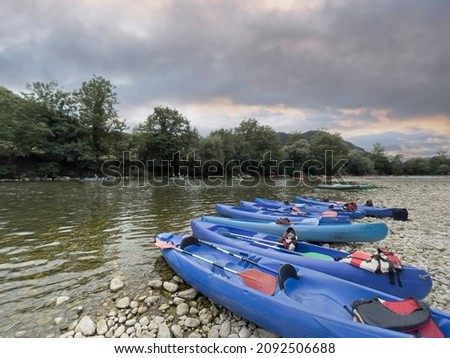 blue kayaks at sunset stranded on the shore of the river Sella in Ribadesella, Asturias, spain, international descent of the Sella River, horizontal Royalty-Free Stock Photo #2092506688