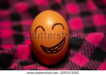 Yellow egg laughs. Picture on the egg