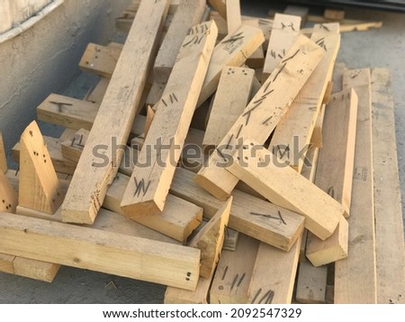 Small size used runner wood pieces with nails stocked for re use them in construction