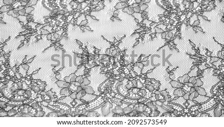 Black lace fabric on a white background. Fancy African polyester and tulle lace fabric with flowers for your design. Texture. Background. Template
