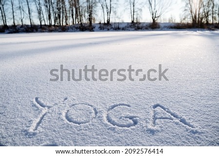 A message in the snow. Yoga in the fresh air. The word yoga is written in the snow. a minimalist picture of Zen Buddhism. Peace and tranquility. High quality photo