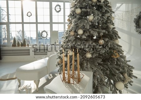 Classical empty room decorate with christmas tree. The room has  white wooden ceilings decorated with pine trees and gift boxes.The arched windows look out to the snow scene.