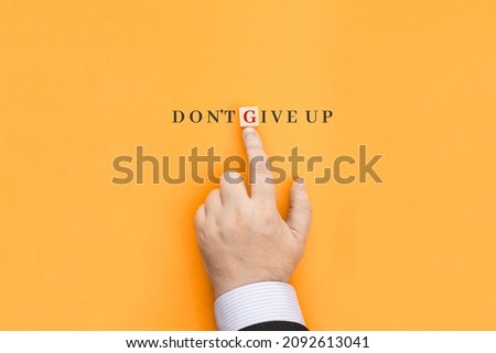 The inscription Don't give up. Means not to stop, to move on, not to stop working. Conceptual photo never give up in order to reach achieve dreams