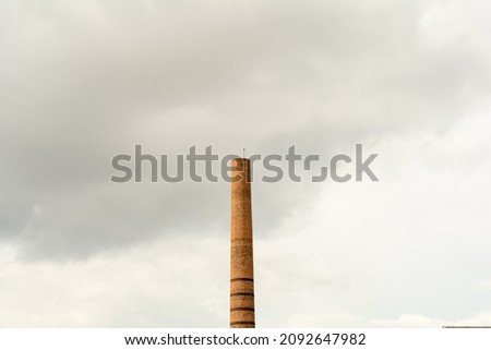 Historical industrial chimney in the center of Eskişehir, Turkey. Smokestack made of red brick. Pipe left over from brick factory. Tower, which is architecturally the symbol of the city. Royalty-Free Stock Photo #2092647982