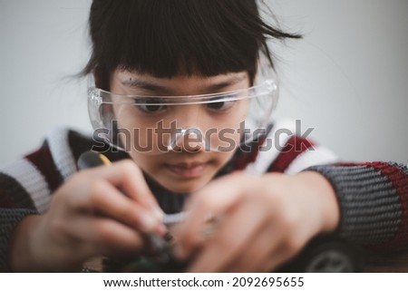 Asia students learn at home in coding robot cars and electronic board cables in STEM, STEAM, mathematics engineering science technology computer code in robotics for kids concept. Royalty-Free Stock Photo #2092695655
