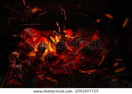 Sparks of fire on a black background. flame of fire with sparks. Burning red hot sparks fly from hot coals in the fire. Beautiful abstract background on the theme of fire, light and life.