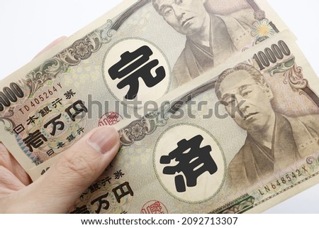 Japanese 10,000 yen bill. This is a concept photo about paying off a debt. Translation: paid off.