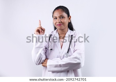 Beautiful portrait of a smiling Indian woman doctor wearing a doctor uniform. 