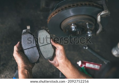New car brake pads compared to old used brake pads. Royalty-Free Stock Photo #2092752256