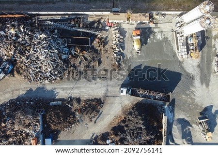 Cranes move metal to compactor. Metal recycling industrial area. Aerial view of machineries working at scrap metal recycling yard.  Royalty-Free Stock Photo #2092756141