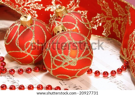 Christmas carol sheet notes with red decorations and ribbon