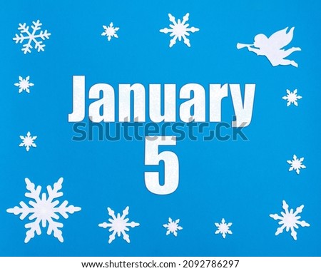 January 5th. Winter blue background with snowflakes, angel and a calendar date. Day 5 of month. Winter month, day of the year concept.
