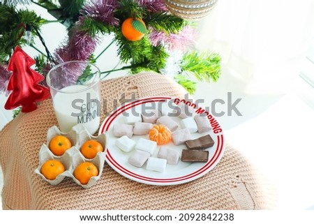 Tangerines in egg box with marshmallow and milk in christmas day.