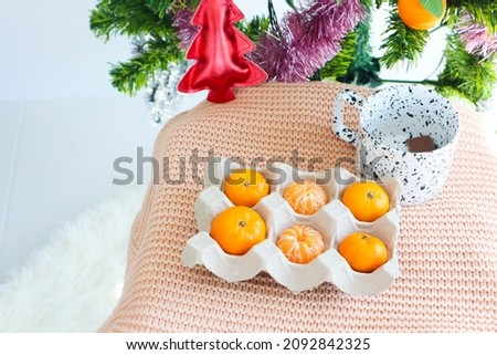 Fresh Tangerines in egg box with on wooden table with christmas tree,christmas concept.