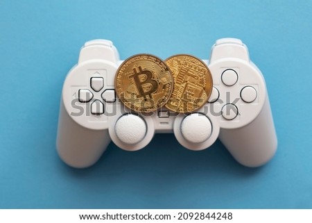 Crypto gaming concept. Video game controller with a bitcoin cryptocurrency coin Royalty-Free Stock Photo #2092844248