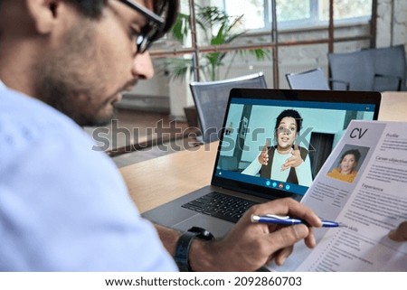 Indian human resource manager holding cv having virtual job interview conversation with remote female candidate during distant business video call on laptop computer. Online recruitment concept. Royalty-Free Stock Photo #2092860703