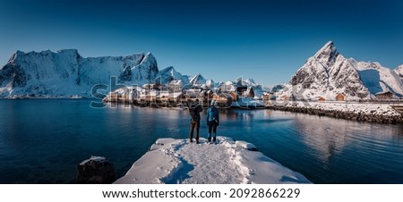 Winter panorama landscape. Lofoten Islands, Norway with red rorbu houses in winter. Concept of Travel and holiday on nature, tourist and fishing leisure. Iconic location for landscape photographers.