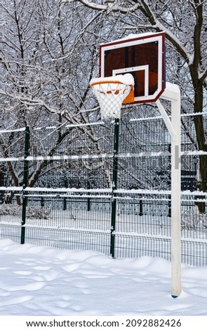 basketball hoop covered with snow on a snowy sports field. High quality photo