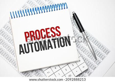 Process Automation inscription in a white notebook on the table next to a calculator, pen, numbers on a sheet of paper. Tax concept