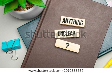 ANYTHING UNCLEAR Conceptual image. text on wood cubes. text in black letters on wood blocks
